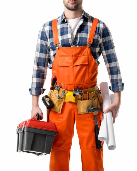 Cropped view of man in orange overall holding tool box and blueprint isolated on white