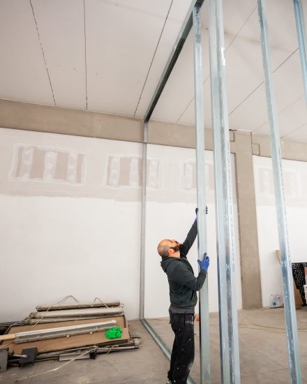 Worker at work in the construction of a plasterboard wall.